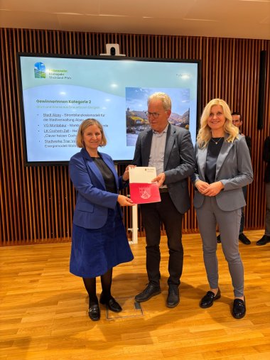 Preisübergabe an den Landkreis Cochem-Zell Ministerin Katrin Eder übergibt die Auszeichnung an den Ersten Kreisbeigeordneten Hans-Joachim Mons und die Referatsleiterin im Eigenbetrieb „Klima & Energie“ Nicole Jobelius-Schausten.