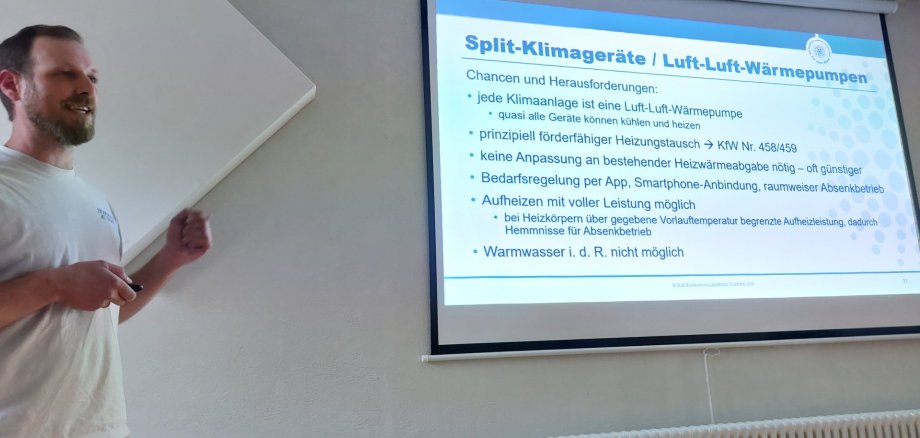 Veranstaltung Sonne nutzen, Zuhause kühlen Foto von Referierendem vor Folie zum Thema Kühlung