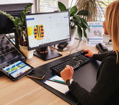 Frau vor Bildschirm mit Solardachkataster