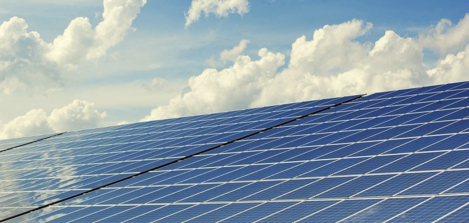 Große Photovoltaikanlage aus der Nähe mit Himmel im Hintergrund 